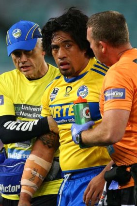 Groggy &#8230; Fuifui Moimoi is escorted from the field after a head-high tackle in the opening minutes of last night's game.
