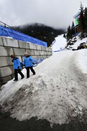 No snow zone . . . Winter Games officials walk off the finish area at Whistler Creekside, venue for the alpine skiing events, which has been less affected by Canada's warm winter.