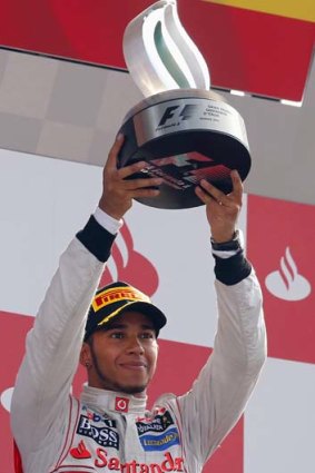 Lewis Hamilton holds up the trophy on the podium after winning the Italian F1 Grand Prix.