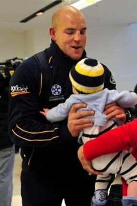 Brumbies hooker Stephen Moore with his son Theodore and wife Courtney at the Canberra airport on his return from South Africa.