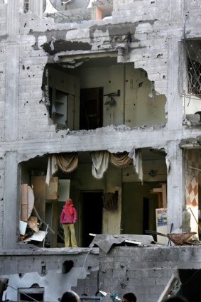 A Palestinian girl stands in her damaged home after an Israeli military strike in Gaza City.