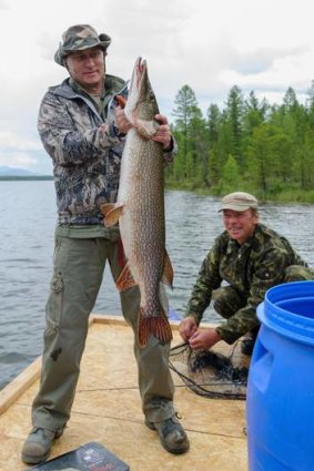 Russian President Vladimir Putin shows a big pike he caught while fishing during a mini-break in the Siberian Tyva region, Russia.