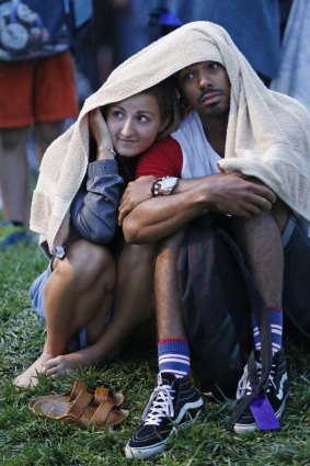 A couple shelter from rain before a  fireworks display  in New York.  