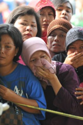 Grief and tears ...  family members identify dead relatives at a hospital in the Sumatran city of Padang yesterday.