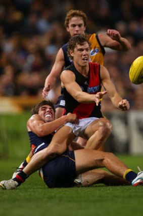 Caught: Essendon's Jake Melksham gets a handball away as he is tackled by Andrew Gaff.