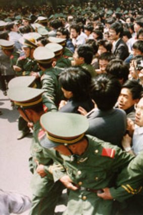 Crowds of students surge through a police cordon before pouring into Tiananmen Square during a pro-democracy demonstration on June 4, 1989.