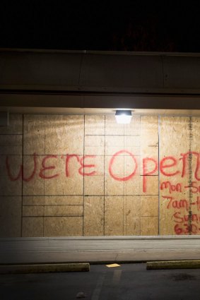 Plywood covers the glass front of shops in Ferguson.