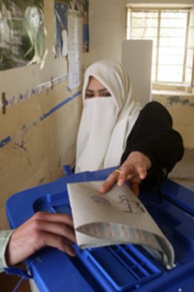 A resident casts her vote at a polling station in Falluja in Iraq's parliamentary election.