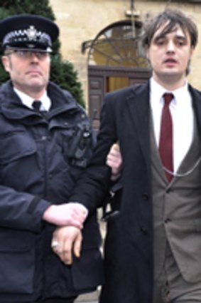 British singer Pete Doherty, second right, is led away by police after appearing at the Crown Court in Gloucester, England.