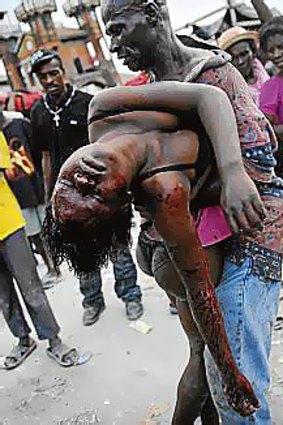 Osam Cherisma carries the body of his daughter Fabienne, who killed by a policeman during looting in Port-au-Prince.