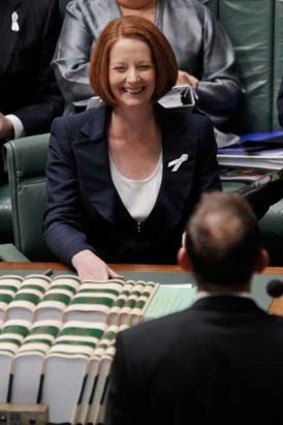 Amused ... Julia Gillard laughs at Tony Abbott’s attempt to block the move.