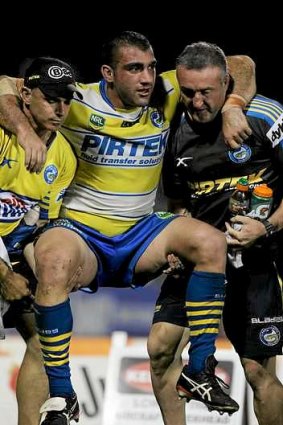 Blow: Tim Mannah is helped off.