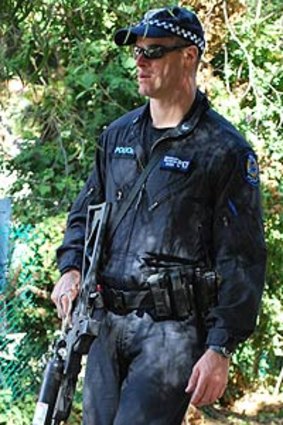 A Tactical Response Group officer patrols near homes in Sayer Street, Swanbourne.