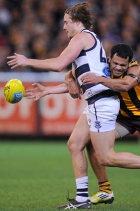 Mitch Duncan is tackled by Hawthorn's Cyril Rioli.