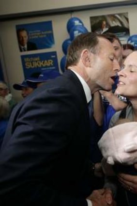 Lip smacker: Tony Abbott bestows a kiss on a mum.