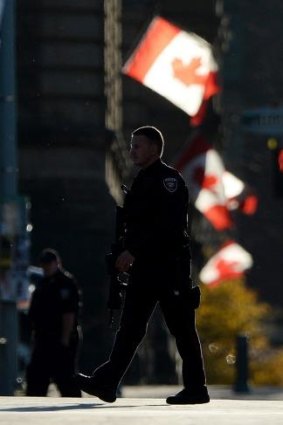 A country shaken: Police continue to patrol a downtown street near the National War Memorial in Ottawa, Ontario.