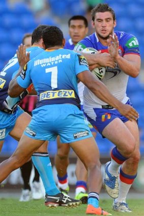 Kade Snowden of the Newcastle Knights is tackled during the round seven match against the Gold Coast Titans on Sunday.