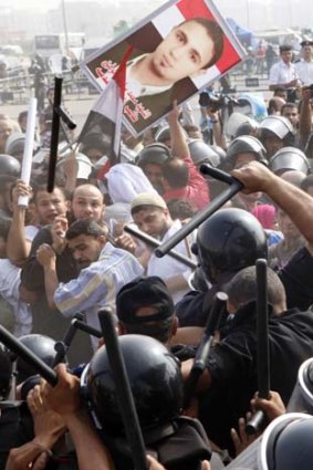 Police beat back protesters outside the court in Cairo.
