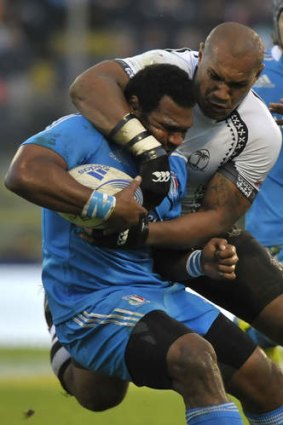 Italy's Manoa Vosawai is grabbed by Fiji's Nemani Nadolo.