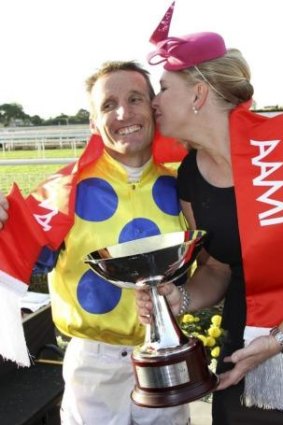 Jockey Damien Oliver gets a peck on the cheek from trainer Natalie McCall for his efforts in the Stradbroke Handicap on Saturday.