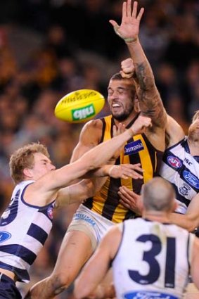 Geelong's Cameron Guthrie and Tom Lonergan spoil Hawthorn's Lance Franklin at the MCG in round 15.