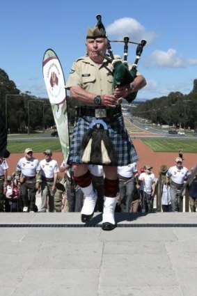Piper leads walk: Bag piper Iain Townsley leads walkers from the Wandering Warriors down ANZAC parade in Canberra as they complete their Brisbane to Canberra challenge. 