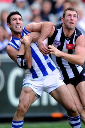 Holds are easier to adjudicate: Collingwood's Travis Cloke battles with North's Michael Firrito at the MCG.
