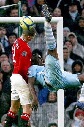 City's Micah Richards makes a gymnastic effort to score, despite the attentions of Chris Smalling.
