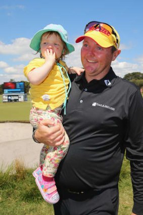 Comback king: Jarrod Lyle leaves the 18th green with his daughter Lusi.