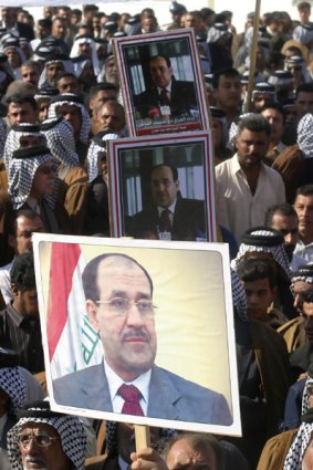 Supporters display posters of Iraq's Prime Minister Nuri al-Maliki during a rally in Kerbala.
