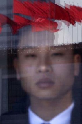 "[Chinese people] are content to be mute as long as they can survive" ... a security guard stands behind a glass door inside the Great Hall of the People in Beijing.