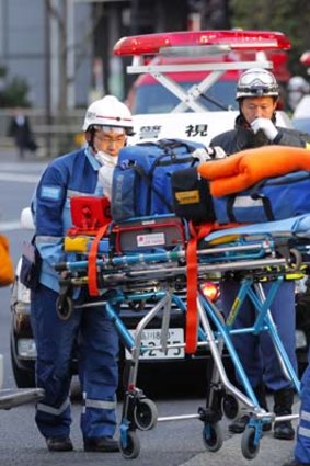 The disaster spreads  ... Tokyo Fire Department rescue workers prepare to treat the injured after a roof collapsed.