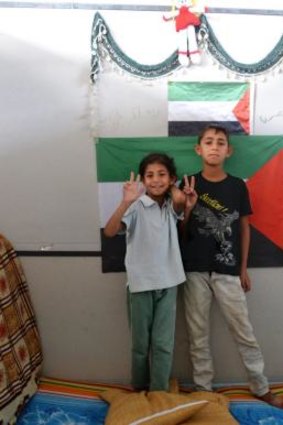 Ashjan, 9, and Marwan, 11, stand in front of a Palestinian flag in a cubicle at a camp for Syrian-based Palestinian refugees near the Turkish-Syrian border.