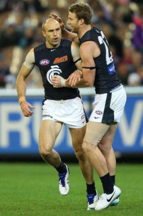 Chris Judd celebrates a goal with Lachie Henderson on Sunday.