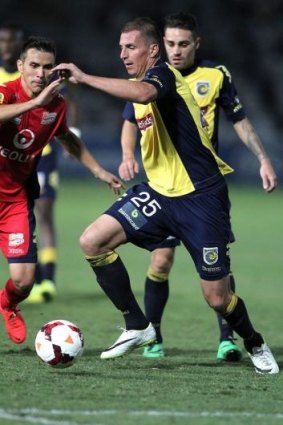 Furious: Mariners defender Eddy Bosnar tries to navigate past Adelaide United at Gosford on Saturday night.