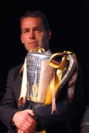 In safe keeping; coach Alastair Clarkson keeps the premiership cup close.