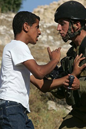 Face to face ... an Israeli soldier confronts a Palestinian protestor during a demonstration at the weekend against Jewish settlements in the West Bank.