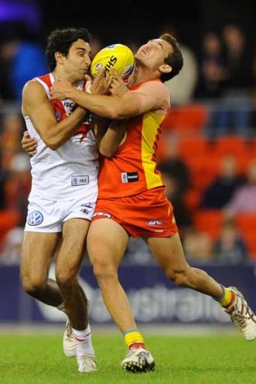 Jarrod Harbrow of the Suns competes for the ball with Trent Dennis-Lane of the Swans during their match at Metricon Stadium.