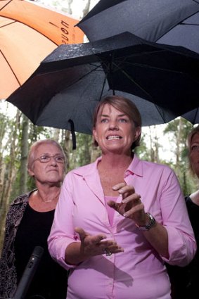 Anna Bligh took shelter from the rain at a policy announcement south of Brisbane yesterday.