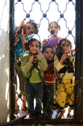 Displaced ... Syrian children wait for food at a school housing around 140 refugees in the village of Atme.