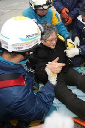 Eighty-year-old Sumi Abe is rescued from the wreckage of her home nine days after the massive 9.0 earthquake and tsunami killed thousands in northern Japan.