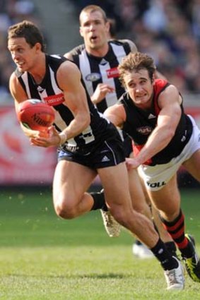 Luke Ball is chased by Essendon's Jobe Watson at the MCG.