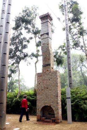 Curator Liza Dale-Hallett stands beside the rebuilt chimney at the Melbourne Museum.
