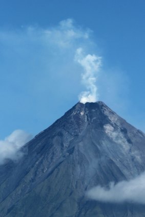 World-renowned perfect cone: Volcano Mayon spews white smoke south-east of Manila.