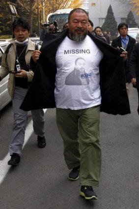 Artist Ai Weiwei reveals a shirt with his portrait as he walks into the government tax office last week.