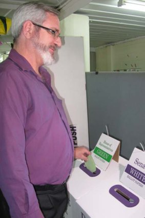 Greens Brisbane electorate candidate Andrew Bartlett drops his vote into the green box.