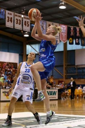 Canberra Capitals forward Abby Bishop drives to the basket as Sydney's Rohanee Cox watches on.
