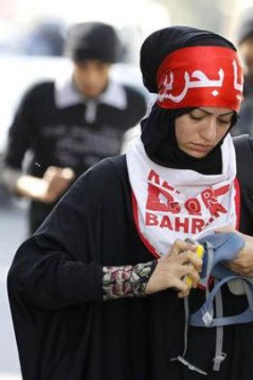 A woman fixes her tear gas mask.