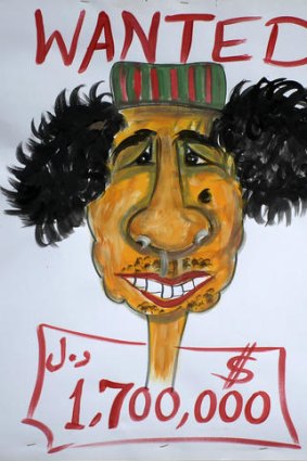 A "wanted" poster shows a drawing of Libya's Moamer Kadhafi, with an offer of 1.7 million dollars reward.