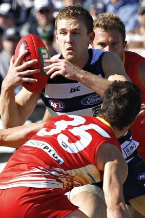 Geelong's Joel Selwood evades Gold Coast's Michael Rischitelli (front) and Jared Brennan at Skilled Stadium.
